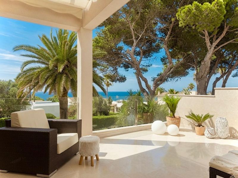 Überdachte Terrasse mit Meerblick und Palmen